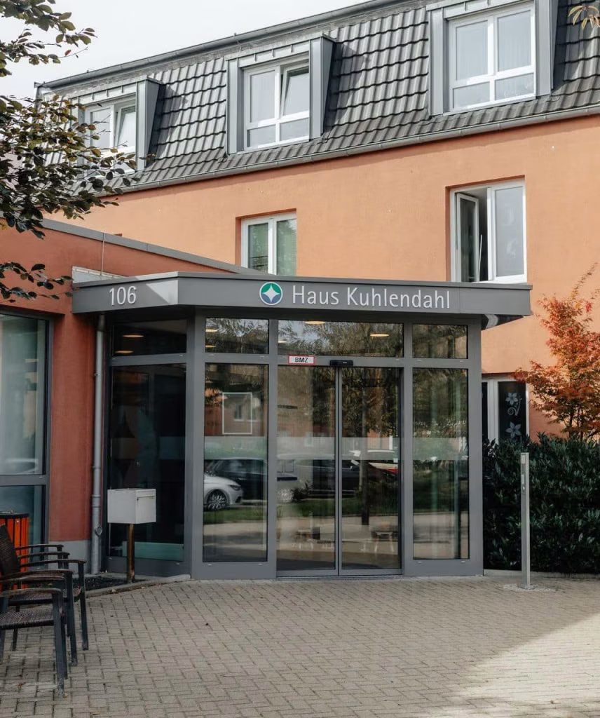 Überdachter Eingang mit Glastüren und der Beschriftung Haus Kuhlendahl.