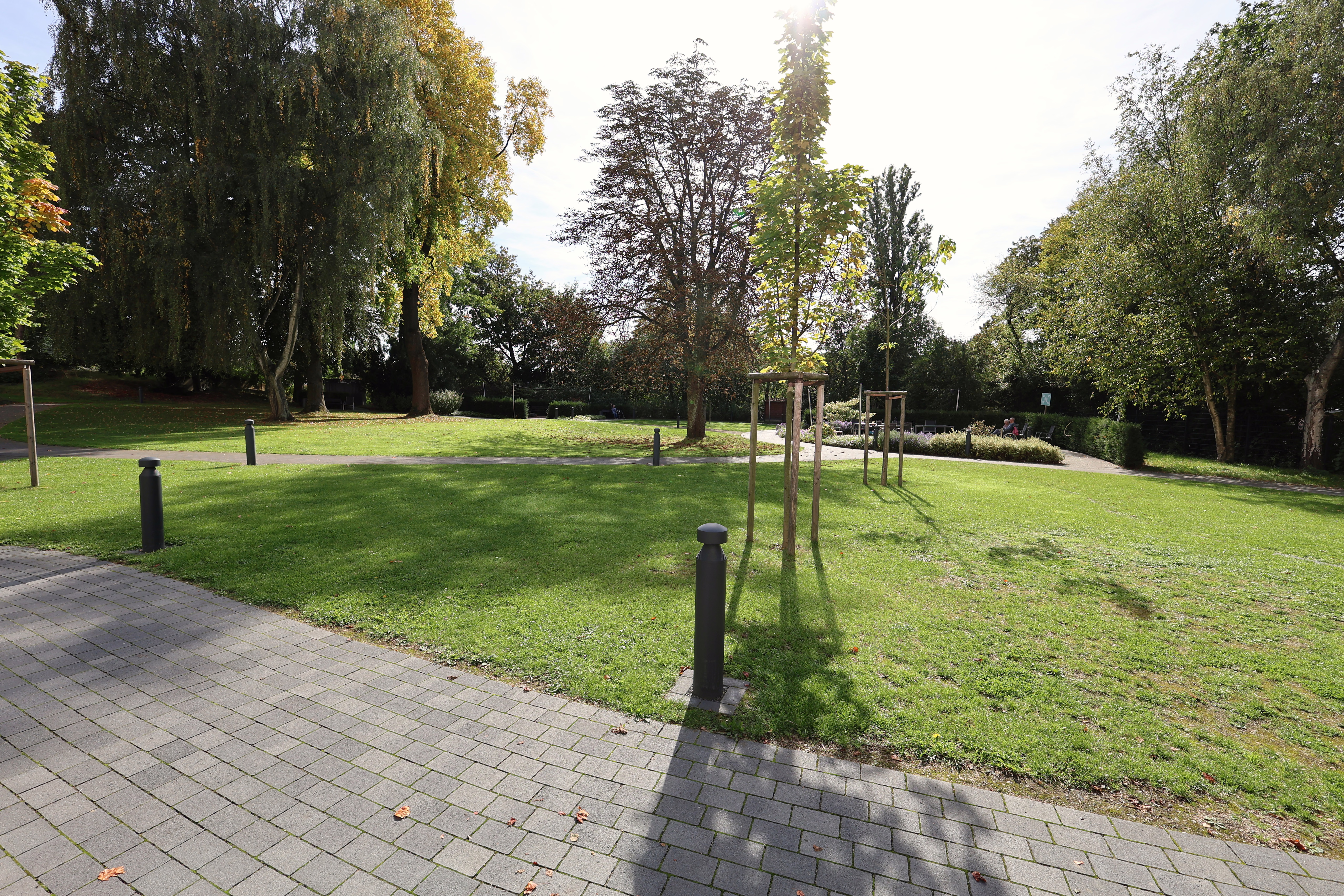 Geschwungene Wege, Rasen und Bäume im Garten des Hauses Gracht.